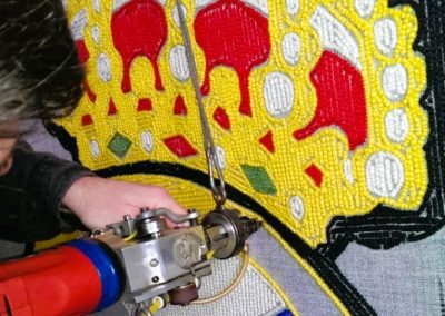 Craftsperson hand-tufting the Real Madrid rug using natural wool