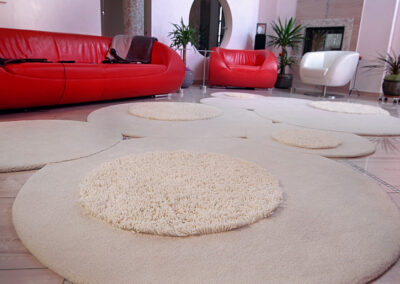 Stylish Custom Rug for Living Room is Custom circular rug in living room with red sofa and contemporary decor