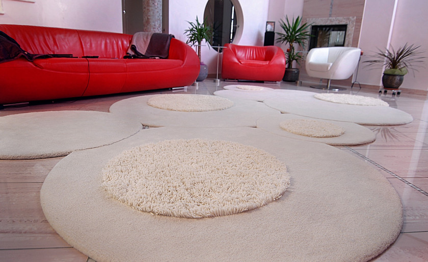 Stylish Custom Rug for Living Room is Custom circular rug in living room with red sofa and contemporary decor