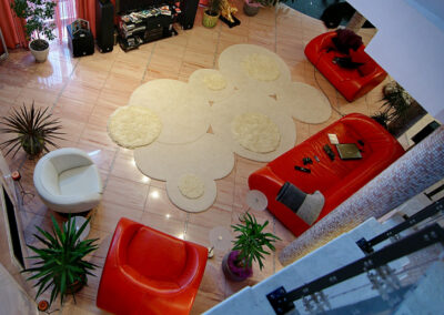 "Top view of designer rug for luxury living room with red and white furniture"