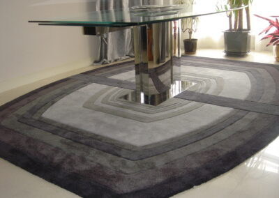 Split rug 10 shades of grey under glass table in interior
