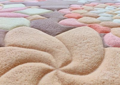 Крупный план овального ковра с цветами, показана рельефная стрижка